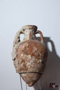 Amphore à deux anses en terre cuite. Epoque Antique. Concrétions et usures. Petits fissure visible dans la partie basse. H. 65 cm env. *Expédition déconseillée.