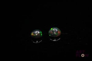 Appairage d'opales noires cabochons ronds. Beaux éclats de couleur. 0.86 ct. Diam. moy.: 6.0mm