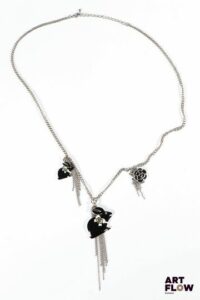 Attribué à CHANEL Collier en métal argenté orné de trois charm's à décor de lapins noirs et blancs et d'une fleur Monogramme Chanel présent sur les lapins Les décors de fleurs occupent une place essentielle dans l’univers joaillier de Chanel, inspirés par la nature chère à Gabrielle Chanel. Longueur : 62 cm