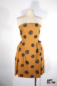 BALENCIAGA - Le Dix - Circa 1980 - Robe bustier en toile de coton et lin de camel rebrodée de cercles de raphia noir, plissée à la taille et rehaussée au dos de deux importants nœuds -Taille présumée 36 - Bon état général malgré quelques très légers défauts
