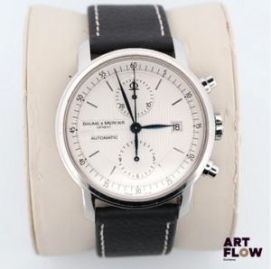 BAUME & MERCIER Classima, Référence 65560 - Montre bracelet chronographe en acier, boitier rond, ouverture au doslaissant apparaître le mouvement, signé. Cadran argenté, index bâtons et aiguilles feuilles, 2 compteurs pour la fonction chronographe. Mouvement automatique cal. BM 1377750, signé. Bracelet en cuir neuf mais boucle d’origine signée dans l’écrin. Diamètre 42mm Accompagné d’une carte de garantie du 03/10/2012 tamponnée « Elysées Horlogerie » à Paris, écrin et sur-boîte, manuel d’utilisation Mouvement opérationnel au moment de la mise en catalogue, mais révision conseillée. Bon état général, quelques rayures d’usage, cadran préservé.