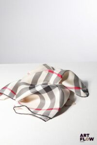 BURBERRY Carré en soie imprimé tartan de couleur beige. 46 x 46 cm. Dans sa pochette cartonnée d'origine. Bon état général malgré quelques légers défauts.