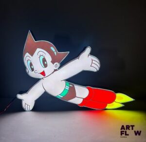 Caisson lumineux Astroboy. Dimensions : 62 x 40 cm Fonctionnelle - État général excellent. Fourni avec son alimentation murale.