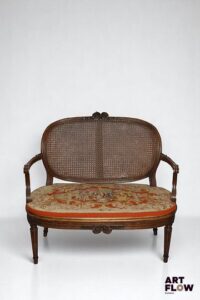 Canapé en bois mouluré et sculpté posant sur pieds cannelés à asperges, assise et dossier à fond de canne ; le dossier orné d'un noeud. Style Louis XVI. H 96 cm Accidents et restaurations.