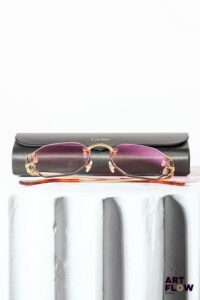 CARTIER Paire de lunettes de soleil, verres roses et branches en métal doré Dans son étui d'origine