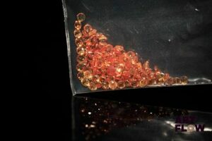 Cent dix saphirs oranges ronds. 3.21 cts. Diam. moy.: 1.7mm