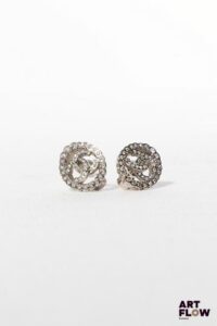 CHANEL Boucles d’oreille ovales en métal argenté et strass, prenant la forme des deux C entrelacés. Siglées au dos sur plaque. 1,5 x 1 cm env. Etat proche du neuf