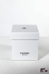 CHANEL Boule à neige figurant un flocon derrière un flacon de parfum n°5 entouré de paquets cadeaux. Dans sa boîte d'origine H. 11,5 cm État neuf