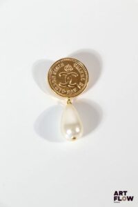 CHANEL Collection Automne/Hiver 1986-1987 Broches imitant une pièce ornée d'une pampille en perle d'imitation Très bon état général Accident (perle à recoller)