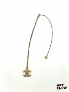 CHANEL Collier en métal doré retenant un pendentif orné de perles. Signé