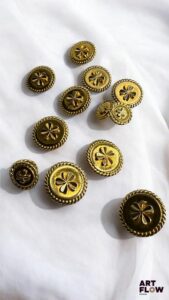 CHANEL Lot de 13 boutons dorés à décor de trèfles, dont 4 plus petits. Quelques petites usures, boutons dédorés par endroits