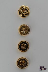 CHANEL Lot de 3 boutons à décor de trèfle. On y joint un bouton en forme de camélia.