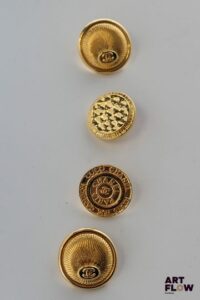CHANEL Lot de 4 boutons, dont deux assortis à décor guilloché rayonnant.