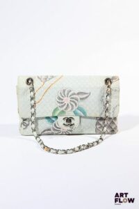 CHANEL Modèle Timeless, 1996 Sac à main en toile pastel à imprimé figurant les accessoires de la maison. Bijouterie en métal argenté. Modèle 25 cm Décolorations et petites traces. Intérieur en cuir blanc en excellent état.