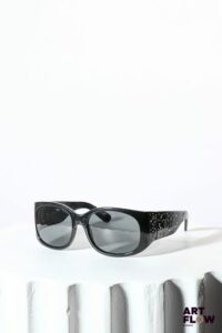 CHANEL Paire de lunettes de soleil noires Incrustées de cristaux Swarovski et ornées de monogrammes en métal argenté Dans son écrin Bon état général (quelques rayures sur les verres)