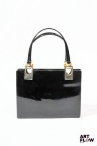 Charles JOURDAN par CESARE PICCINI Sac à main en cuir verni noir et bijouterie en metal doré, à 3 soufflets, l'intérieur pourvu d'un miroir. Dimensions : 17 x 21 cm (sans les anses). Rayures d'usage, traces