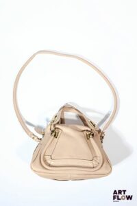 CHLOE Sac modèle "Paraty" en cuir biscotti beige Fermeture par un grand zip doré ouvrant sur un compartiment en toile beige avec une poche zippée et une petite poche plaquée, deux anses pour un porté main, large bandoulière pour un porté épaule. 36 x 21 x 13 cm. Avec étiquettes Très bon état général malgré quelques légers défauts (petite tache, petites usures d'usage, petites poussières)