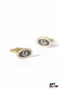 CHRISTIAN DIOR Boutons de manchette en métal doré monogrammés et sertis de strass Dimensions : 1,3 x 1,8 cm Fournie avec son écrin d'origine