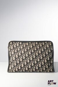 CHRISTIAN DIOR Vanity en toile monogrammée beige et noir en oblique. Fermeture à glissière. Intérieur en toile enduite beige. H. 21 x L. 30 x P. 9,5 cm. Bon état général malgré quelques défauts (usures d'usage).