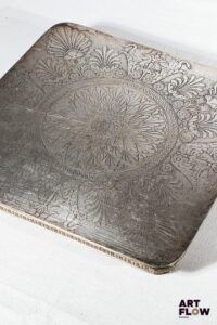 CHRISTOFLE Malmaison Dessous de plat carré en métal argenté à décor Empire ciselé de palmettes, cygnes et rinceaux. Reposant sur quatre pieds en gaine. Signé. Dans sa boîte d'origine. 22,5 x 22,5 cm Bon état général malgré quelques légers défauts (rayures d'usage).