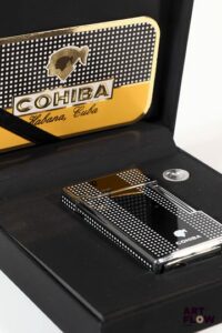 COHIBA Briquet en métal argenté laqué à décor géométrique noir et blanc Bande verticale laquée noir 6,5 x 3,5 cm Dans son écrin Très bon état général