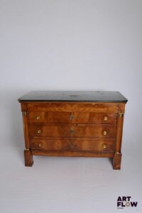 Commode en acajou et placage d'acajou ouvrant a quatre tiroirs à traverses, à décor de colonnes détachées, ornementation de bronze doré et dessus de marbre noir. Époque Empire. 91 x 130 x 60 cm Bon état général malgré de petits accidents et restaurations (notamment fentes réparées sur les côtés) Facture de réparation et nettoyage de mai 2011.