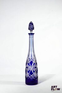 Dans le goût de Baccarat Carafe en cristal bicolore à décor géométrique gravé H 33,5 cm avec bouchon. Quelques accidents (rayures et éclat au bouchon)