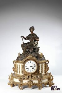 DELAROUE Pendule en marbre et bronze doré patiné à decor d'un personnage portant une couronne de laurier Cadran marqué "Delaroue à Lyon" Fin XIXème siècle H.48 x L.36 x P. 13 cm environ Bon état général malgré quelques légers défauts (balancier décroché, accident sur le verre arrière)