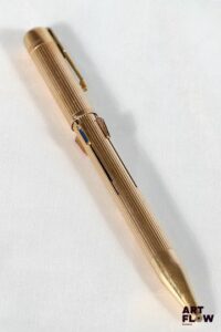 DUPONT Stylo quatre couleurs plaqué or à décor rainuré Longueur : 13,5 cm Bon état général malgré quelques légers défauts (usures d'usage)