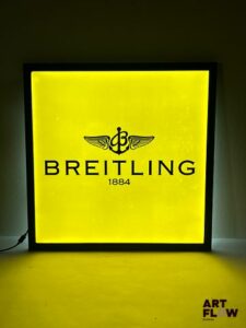 Enseigne lumineuse publicitaire Breitling. Dimensions : 60 x 60 cm Fonctionnelle - État général excellent. Fourni avec son alimentation murale.
