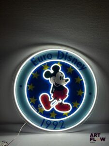 Enseigne lumineuse publicitaire Euro Disney représentant Mickey. Diamètre : 58 cm Fonctionnelle - État général excellent. Fourni avec son alimentation murale.