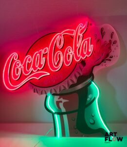 Enseigne lumineuse publicitaire sur plexiglas Coca Cola. Dimensions : 89 x 92 cm Fonctionnelle - endommagée à l'extrémité supérieure. Fourni avec son alimentation murale.