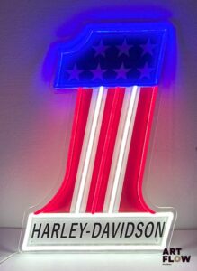 Enseigne lumineuse publicitaire sur plexiglas Harley Davidson. Dimensions : 51 x 33 cm Fonctionnelle - État général excellent. Fourni avec son alimentation murale.