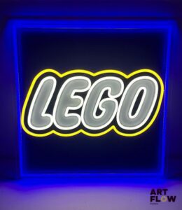Enseigne lumineuse publicitaire sur plexiglas Lego. Dimensions : 50 x 50 cm Fonctionnelle - État général excellent. Fourni avec son alimentation murale.
