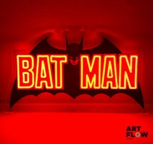 Enseigne lumineuse sur plexiglas Batman. Dimensions : 30 x 59 cm Fonctionnelle - État général excellent. Fourni avec son alimentation murale.