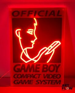 Enseigne lumineuse sur plexiglas Game Boy. Dimensions : 50 x 35 cm Fonctionnelle - État général excellent. Fourni avec son alimentation murale.