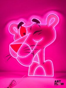 Enseigne lumineuse sur plexiglas La Panthère Rose. Dimensions : 60 x 56 cm Fonctionnelle - État général excellent. Fourni avec son alimentation murale.