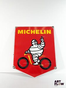 Grande plaque émaillée d'après Michelin - bonhomme Michelin faisant du vélo 55 x 44,5 cm Petits éclats et traces de rouille. Moderne