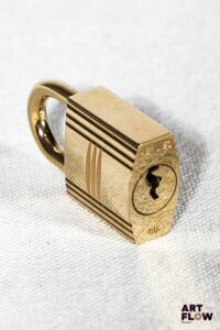 HERMÈS Cadenas en métal doré gravé d'un H n°107 avec ses deux clés 3,5 x 2 cm Très bon état général malgré quelques très légers défauts (Petites usures d'usage)