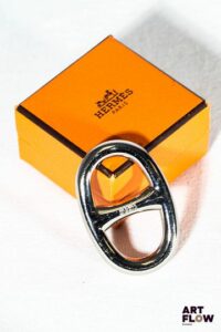 HERMÈS Chaîne d'encre Anneau de foulard en métal argenté. Dans une boîte 5,5 x 4 cm env. Très bon état général malgré quelques très légers défauts (petites usures d'usage)