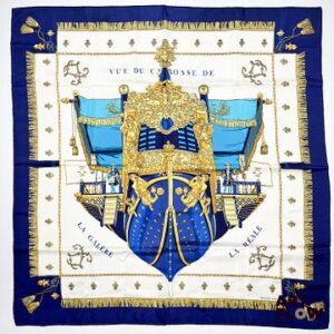 HERMÈS Modèle "La Réale". Carré en twill de soie à bordure bleue marine. 90 × 90 cm. Bon état général malgré quelques légers défauts.
