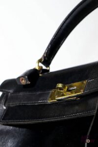 Hermes Sac Kelly 28 vintage en cuir box noir, bijouterie en métal doré. Avec cadenas, clés et clochette. Usures, état conforme à l'âge de la pièce.