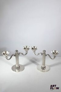 Jean DESPRES (1889-1980) Paire de chandeliers à 2 lumières en métal argenté, à décor de chaines et fut cannelé. Signé J. DESPRES à la pointe sous la base. Haut. : 20 cm L. : 26,5 cm Rayures d'usage