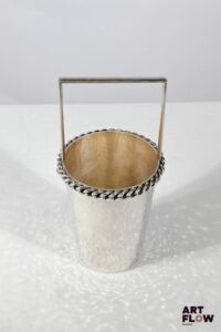 Jean DESPRES (1889-1980) Seau à glace en métal argenté martelé, le col souligné d'une chaine. Signé J. DESPRES à la pointe sous la base. Haut. : 21,5 cm Diam. : 10 cm Dans sa boite d'origine Rayures d'usage