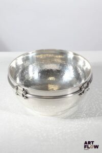 Jean DESPRES (1889-1980) Soupière ou grand bol sur talon en métal argenté partiellement martelé. Signé J. DESPRES à la pointe sous la base. Haut. : 9,5 cm Diam. : 19,5 cm Dans sa boite d'origine Rayures d'usage