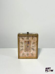 JUVENIA Pendule flacon en bronze doré et marbre jaune, cadran en marqueterie de nacre, aiguilles Breguet, index en chiffres arabe peints, signée au dos 8 x 6 cm Bon état général (absence du bouchon initialement sur le remontoir) Juvenia est une manufacture horlogère suisse fondée en 1860 à La Chaux-de-Fonds. Elle s’est illustrée par des montres élégantes et innovantes, notamment des boîtiers à ouverture frontale et des mouvements de haute qualité. Au XXᵉ siècle, Juvenia devient une marque reconnue internationalement, symbole du raffinement horloger suisse.