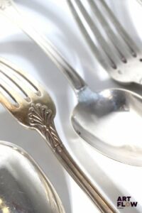 Lot de 12 couverts en argent (12 fourchettes et 13 cuillères), à décor de rinceaux stylisés. Monogrammés. Poids : 1936,51 grammes