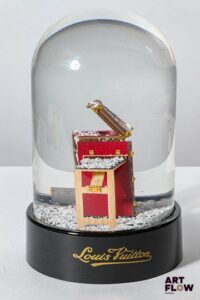 LOUIS VUITTON Boule à neige figurant une malle de voyage. Edition limitée offerte aux clients VIP. Fonctionnelle. H. 15 cm Dans sa boîte d’origine Etat comme neuf