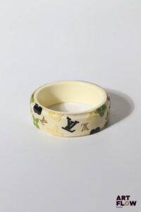 LOUIS VUITTON Bracelet "Inclusions" en résine a fond crème et motifs multicolores. Diamètre intérieur : 6,5 cm H. : 2,5 cm