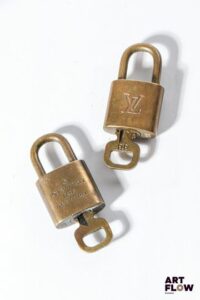 LOUIS VUITTON Ensemble de deux cadenas en métal doré monogrammés Dimensions : 4 cm